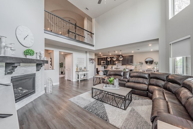 407 Emerson Dr, Rockwall, TX 75087 - living room with a high ceiling, ceiling fan, wood finished floors, and a glass covered fireplace