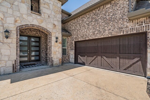407 Emerson Dr, Rockwall, TX 75087 - property entrance with french doors, brick siding, stone siding, and a garage