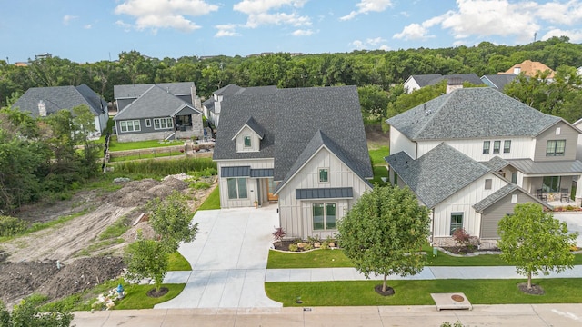 1022 Bow St, Rockwall, TX 75087 - view of front of house with board and batten siding, concrete driveway, a residential view, a shingled roof, and a front lawn