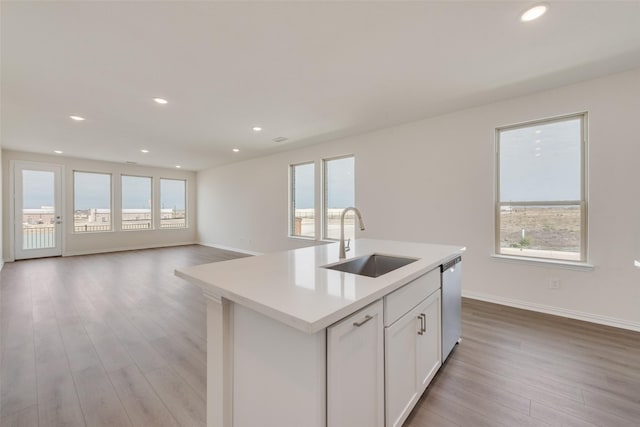 1502 Salem Dr, Forney, TX 75126 - kitchen featuring stainless steel dishwasher, light wood-type flooring, white cabinets, a center island with sink, and light countertops