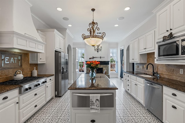 2305 Castle Creek Dr, Mansfield, TX 76063 - kitchen featuring custom exhaust hood, appliances with stainless steel finishes, a warming drawer, crown molding, and white cabinetry