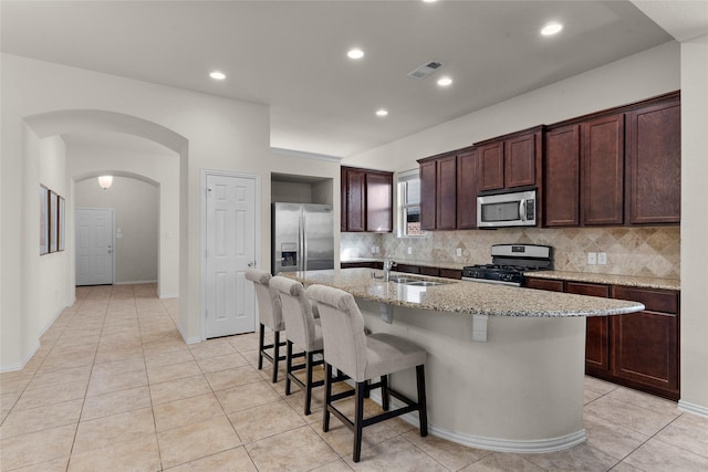 5201 Datewood Ln, Mckinney, TX 75071 - kitchen with stainless steel appliances, backsplash, arched walkways, a kitchen breakfast bar, and recessed lighting