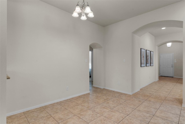 5201 Datewood Ln, Mckinney, TX 75071 - empty room featuring arched walkways, light tile patterned floors, and a chandelier