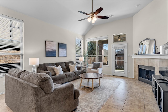 5201 Datewood Ln, Mckinney, TX 75071 - living room featuring a tile fireplace, healthy amount of natural light, ceiling fan, light tile patterned floors, and high vaulted ceiling