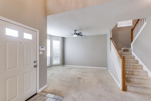 7504 Lomo Alto, Plano, TX 75024 - foyer entrance with stairs, light colored carpet, a ceiling fan, and a textured ceiling
