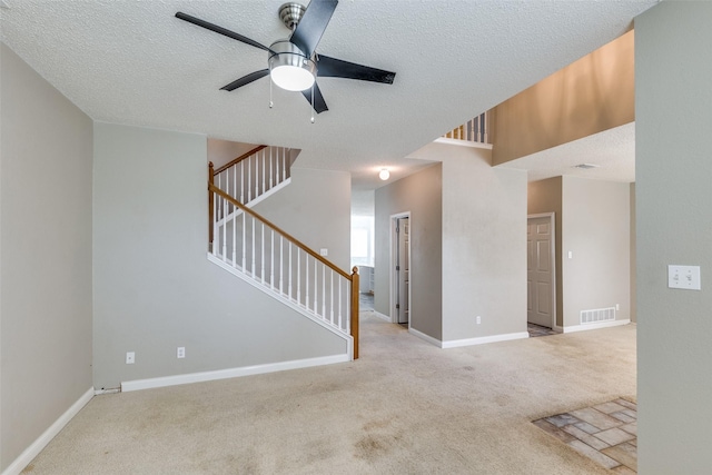 7504 Lomo Alto, Plano, TX 75024 - unfurnished living room with a ceiling fan, carpet, stairs, and a textured ceiling
