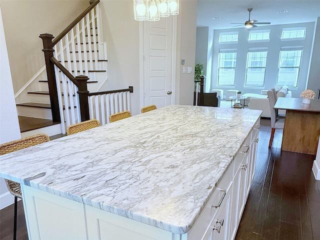 5339 Holland Ave, Dallas, TX 75209 - kitchen featuring dark wood-style flooring, white cabinets, a kitchen breakfast bar, and a kitchen island