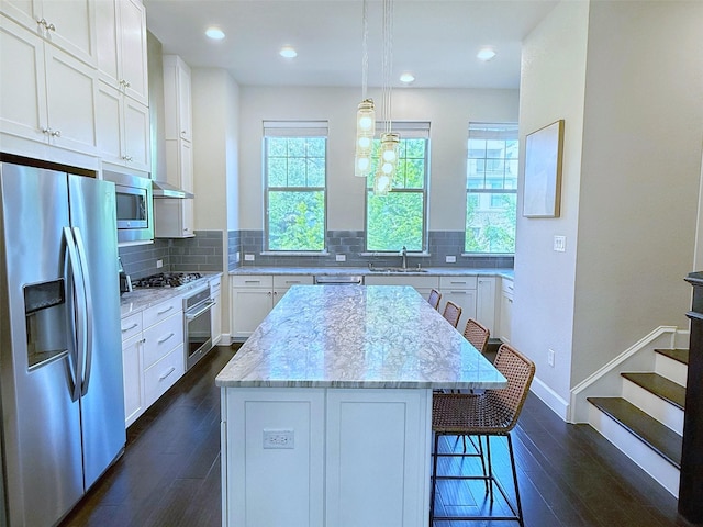5339 Holland Ave, Dallas, TX 75209 - kitchen featuring appliances with stainless steel finishes, dark wood-style floors, white cabinetry, a center island, and recessed lighting
