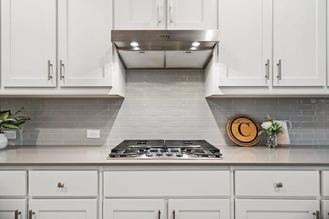 3680 Twin Pines Dr, Grand Prairie, TX 76065 - kitchen with under cabinet range hood, stainless steel gas cooktop, white cabinetry, and backsplash