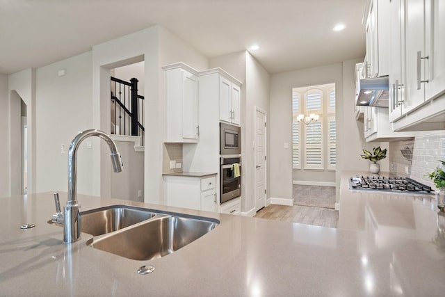 3680 Twin Pines Dr, Grand Prairie, TX 76065 - kitchen with appliances with stainless steel finishes, range hood, decorative backsplash, light wood-style flooring, and white cabinetry
