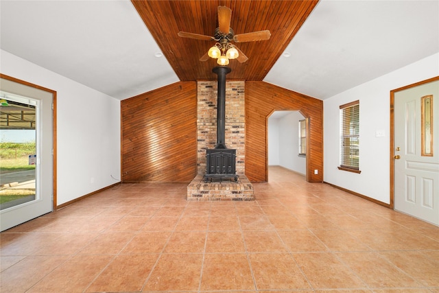 10900 Fm 1189, Lipan, TX 76462 - unfurnished living room with a wood stove, wooden walls, vaulted ceiling, light tile patterned floors, and ceiling fan