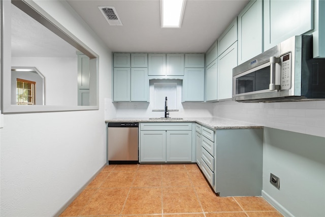 10900 Fm 1189, Lipan, TX 76462 - kitchen featuring appliances with stainless steel finishes, light tile patterned flooring, decorative backsplash, and light stone countertops