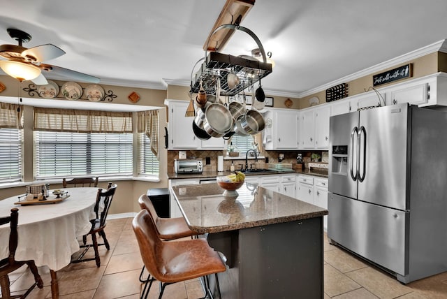 112 Rolling Meadow Ln, Bossier City, LA 71112 - kitchen featuring stainless steel fridge with ice dispenser, plenty of natural light, light tile patterned floors, and ornamental molding