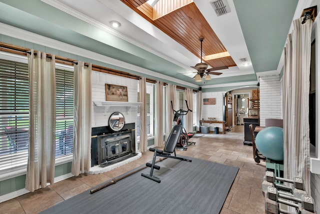 112 Rolling Meadow Ln, Bossier City, LA 71112 - exercise room with a tray ceiling, a ceiling fan, arched walkways, a fireplace, and stone tile flooring