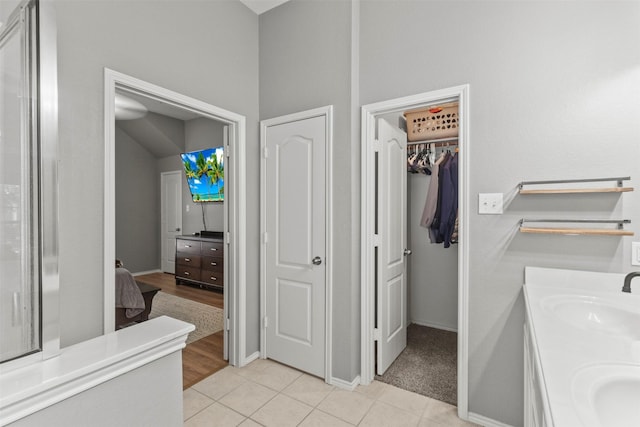 1732 Jasmine Trl, Savannah, TX 76227 - bathroom with double vanity, a spacious closet, and tile patterned flooring