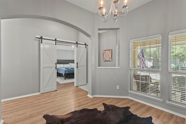 1732 Jasmine Trl, Savannah, TX 76227 - entryway featuring a barn door, light wood finished floors, a chandelier, and arched walkways