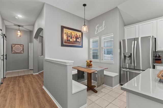 1732 Jasmine Trl, Savannah, TX 76227 - kitchen with stainless steel refrigerator with ice dispenser, light countertops, white cabinets, and pendant lighting