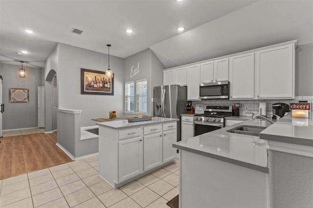 1732 Jasmine Trl, Savannah, TX 76227 - kitchen featuring stainless steel appliances, arched walkways, tasteful backsplash, white cabinets, and lofted ceiling