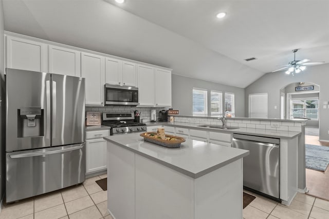 1732 Jasmine Trl, Savannah, TX 76227 - kitchen with appliances with stainless steel finishes, a peninsula, vaulted ceiling, white cabinetry, and light tile patterned floors