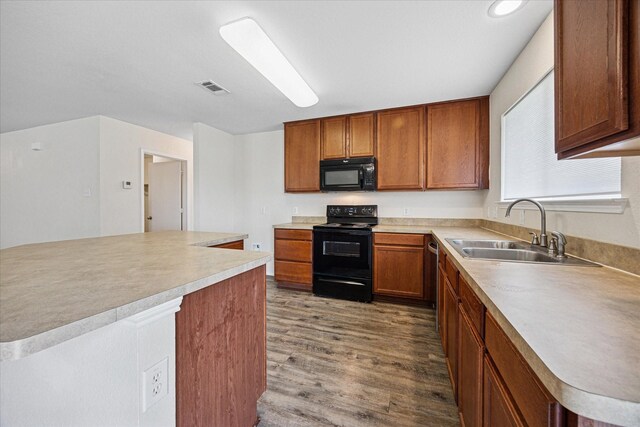 330 Broken Bow, Krum, TX 76249 - kitchen featuring black appliances, wood finished floors, light countertops, and brown cabinets