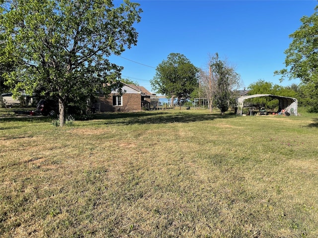 10074 County Road 200, Breckenridge, TX 76424 - view of grassy yard with a detached carport