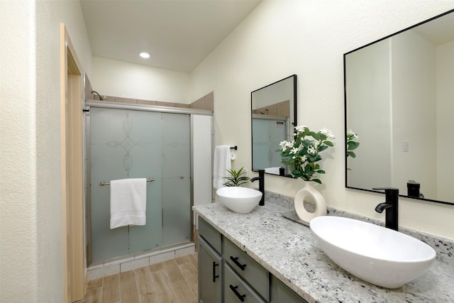 2621 Canton Dr, Fort Worth, TX 76112 - bathroom featuring double vanity, a shower stall, wood finished floors, and recessed lighting