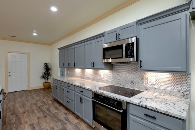 2621 Canton Dr, Fort Worth, TX 76112 - kitchen with appliances with stainless steel finishes, ornamental molding, tasteful backsplash, gray cabinetry, and light stone countertops