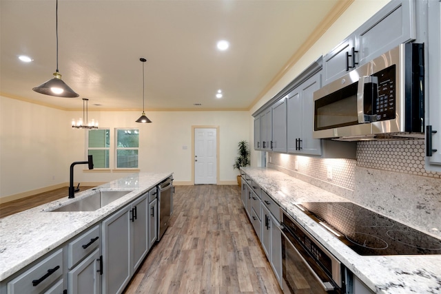 2621 Canton Dr, Fort Worth, TX 76112 - kitchen featuring appliances with stainless steel finishes, gray cabinetry, light wood finished floors, crown molding, and recessed lighting