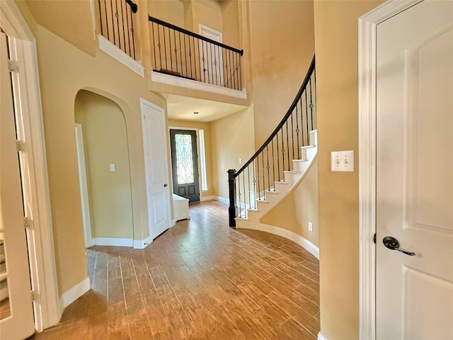 14249 Fall Harvest Dr, Frisco, TX 75033 - foyer with wood finished floors, a high ceiling, stairway, and arched walkways