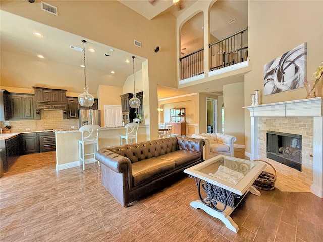 14249 Fall Harvest Dr, Frisco, TX 75033 - living area with a brick fireplace, a high ceiling, light wood finished floors, and recessed lighting