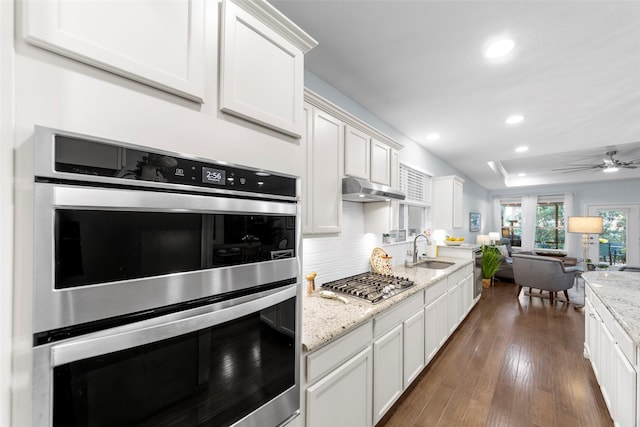2142 Flagship Ct, Frisco, TX 75036 - kitchen featuring appliances with stainless steel finishes, open floor plan, white cabinets, recessed lighting, and under cabinet range hood