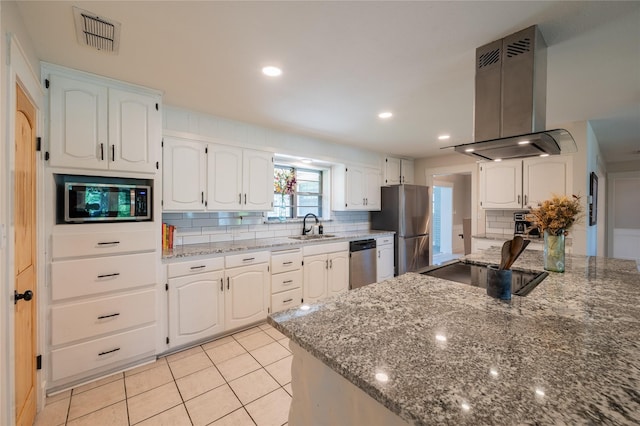 18 Tula Ct, Nocona, TX 76255 - kitchen with island range hood, stainless steel appliances, tasteful backsplash, dark stone countertops, and recessed lighting