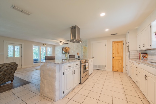 18 Tula Ct, Nocona, TX 76255 - kitchen with stainless steel range with electric stovetop, island exhaust hood, light tile patterned floors, a kitchen island, and tasteful backsplash