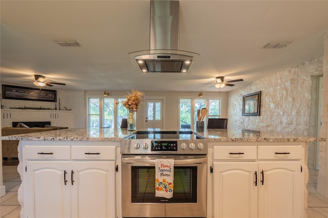 18 Tula Ct, Nocona, TX 76255 - kitchen featuring stainless steel range with electric stovetop, a ceiling fan, island exhaust hood, and open floor plan