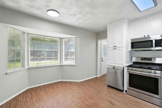 324 Jasmine Ct, Burleson, TX 76028 - kitchen featuring stainless steel appliances, backsplash, light wood-type flooring, and white cabinetry