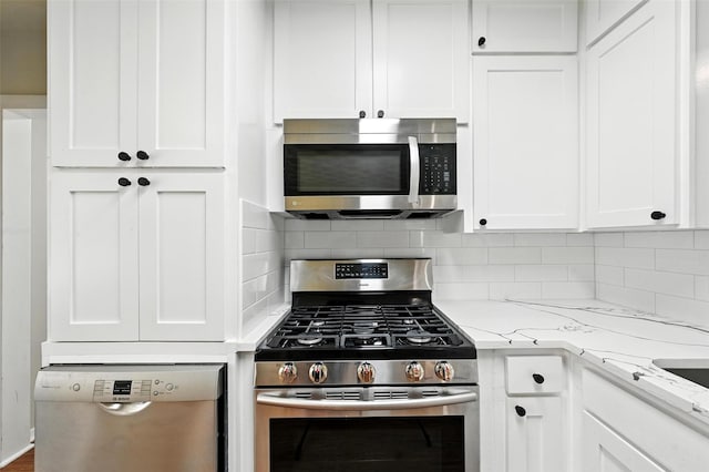 324 Jasmine Ct, Burleson, TX 76028 - kitchen featuring appliances with stainless steel finishes, white cabinetry, backsplash, and light stone counters