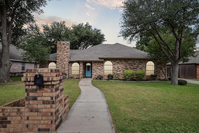 1112 Indian Ridge Dr, Denton, TX 76205 - view of front of home with roof with shingles, a chimney, a lawn, and brick siding