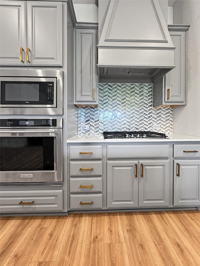3978 Sidney Ln, Heath, TX 75126 - kitchen featuring stainless steel appliances, gray cabinets, premium range hood, and decorative backsplash