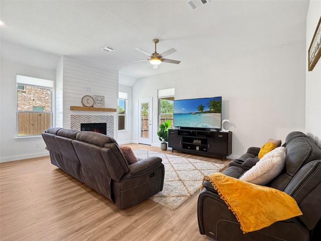 3978 Sidney Ln, Heath, TX 75126 - living area with ceiling fan, light wood-style flooring, a tiled fireplace, and vaulted ceiling