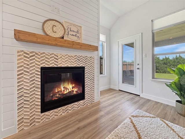 3978 Sidney Ln, Heath, TX 75126 - unfurnished living room featuring lofted ceiling, a tiled fireplace, and wood finished floors
