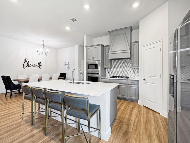 3978 Sidney Ln, Heath, TX 75126 - kitchen with gray cabinetry, appliances with stainless steel finishes, custom range hood, a center island with sink, and recessed lighting