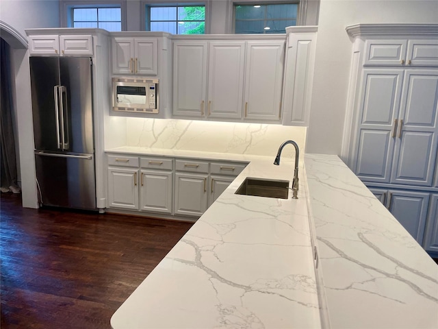 4139 Herschel Ave, Dallas, TX 75219 - kitchen featuring high quality fridge, white microwave, dark wood-type flooring, light stone counters, and white cabinets