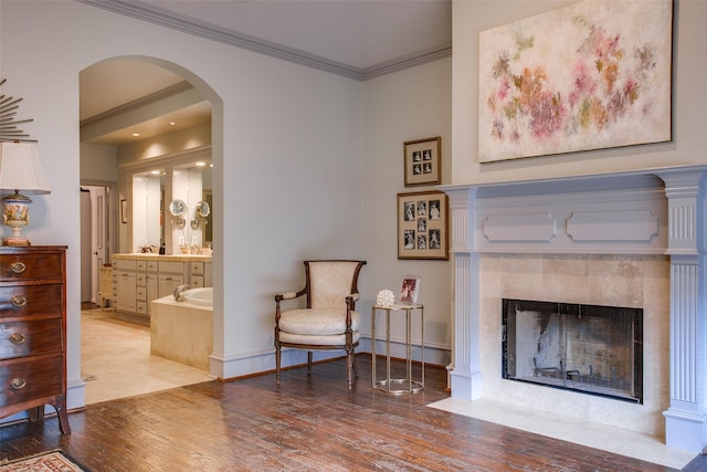 4139 Herschel Ave, Dallas, TX 75219 - sitting room featuring wood finished floors, arched walkways, ornamental molding, and a fireplace