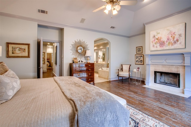 4139 Herschel Ave, Dallas, TX 75219 - bedroom featuring arched walkways, wood finished floors, crown molding, a tile fireplace, and ensuite bath