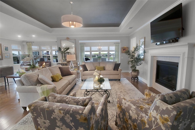 717 Freedom Ln, Aubrey, TX 76227 - living room with a tray ceiling, crown molding, wood finished floors, recessed lighting, and a glass covered fireplace