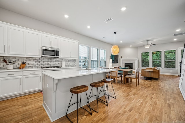 420 Waterscape Dr Unit 1237, Lake Dallas, TX 75065 - kitchen with stainless steel microwave, gas stovetop, healthy amount of natural light, light wood finished floors, and recessed lighting