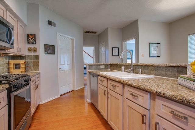 18423 Rain Dance Trl, Dallas, TX 75252 - kitchen with stainless steel appliances, light wood-style floors, tasteful backsplash, light stone countertops, and light brown cabinetry