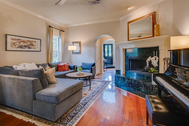 18423 Rain Dance Trl, Dallas, TX 75252 - living room featuring arched walkways, a high end fireplace, hardwood / wood-style flooring, ornamental molding, and a textured ceiling