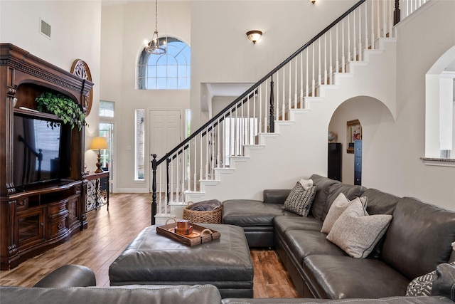 204 Oregon Trl, Argyle, TX 76226 - living room with a high ceiling, arched walkways, wood finished floors, stairway, and a chandelier