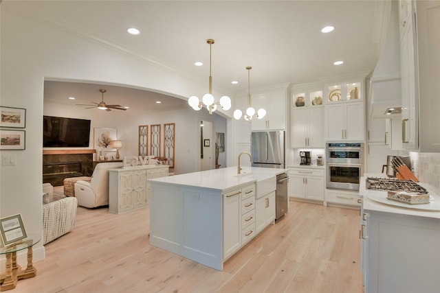 1001 Quarry Ct, Granbury, TX 76048 - kitchen featuring stainless steel appliances, crown molding, light countertops, open floor plan, and light wood-style flooring